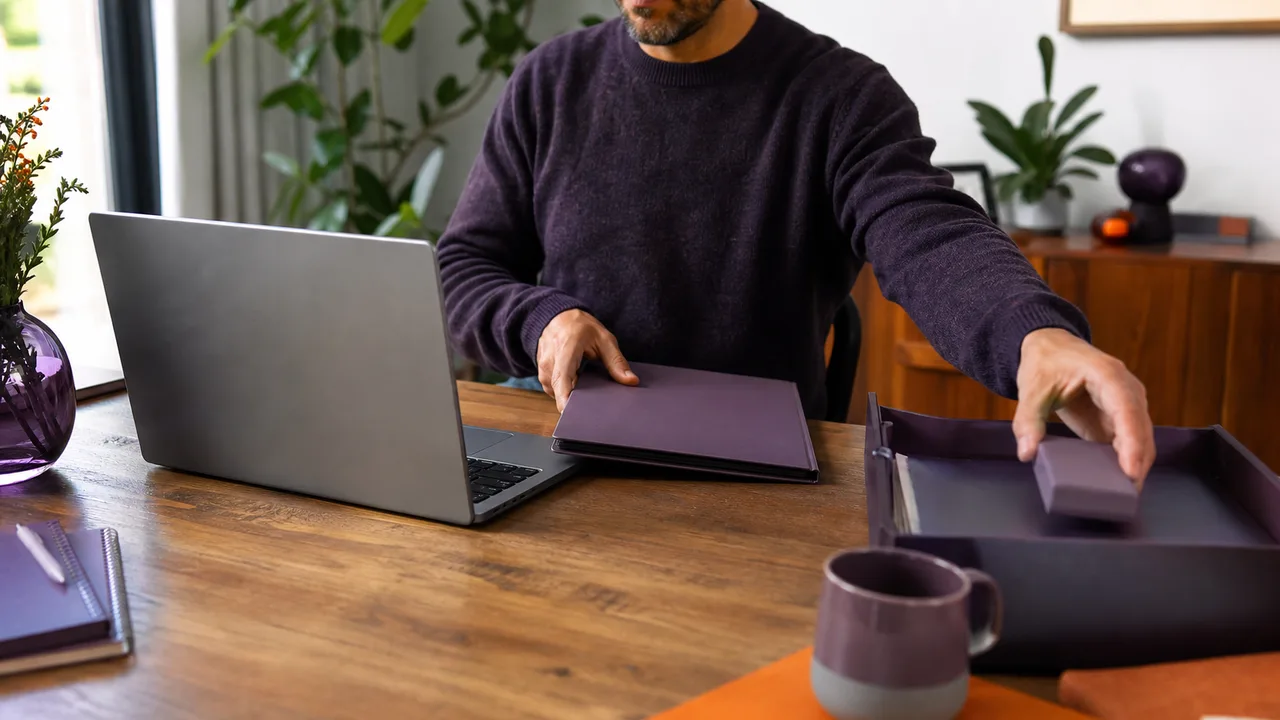 Un professionnel sort un dossier concret du bac de réception pour le placer dans son espace de travail.