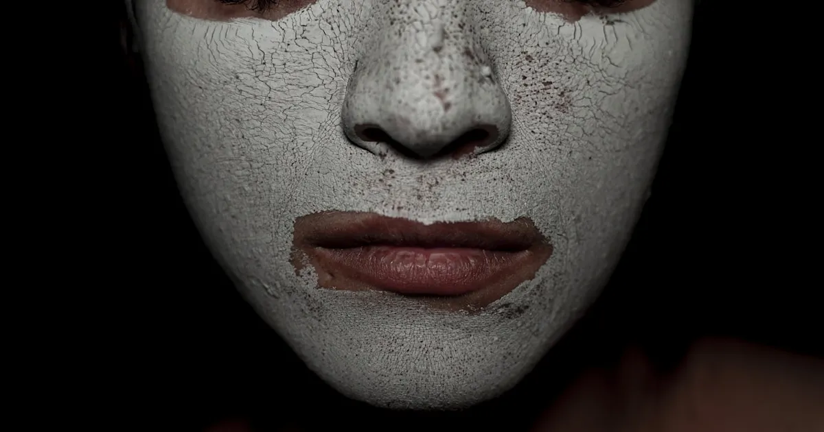 Visage recouvert d'un masque d'argile craquele, metaphore du masking TDAH qui finit par se fissurer